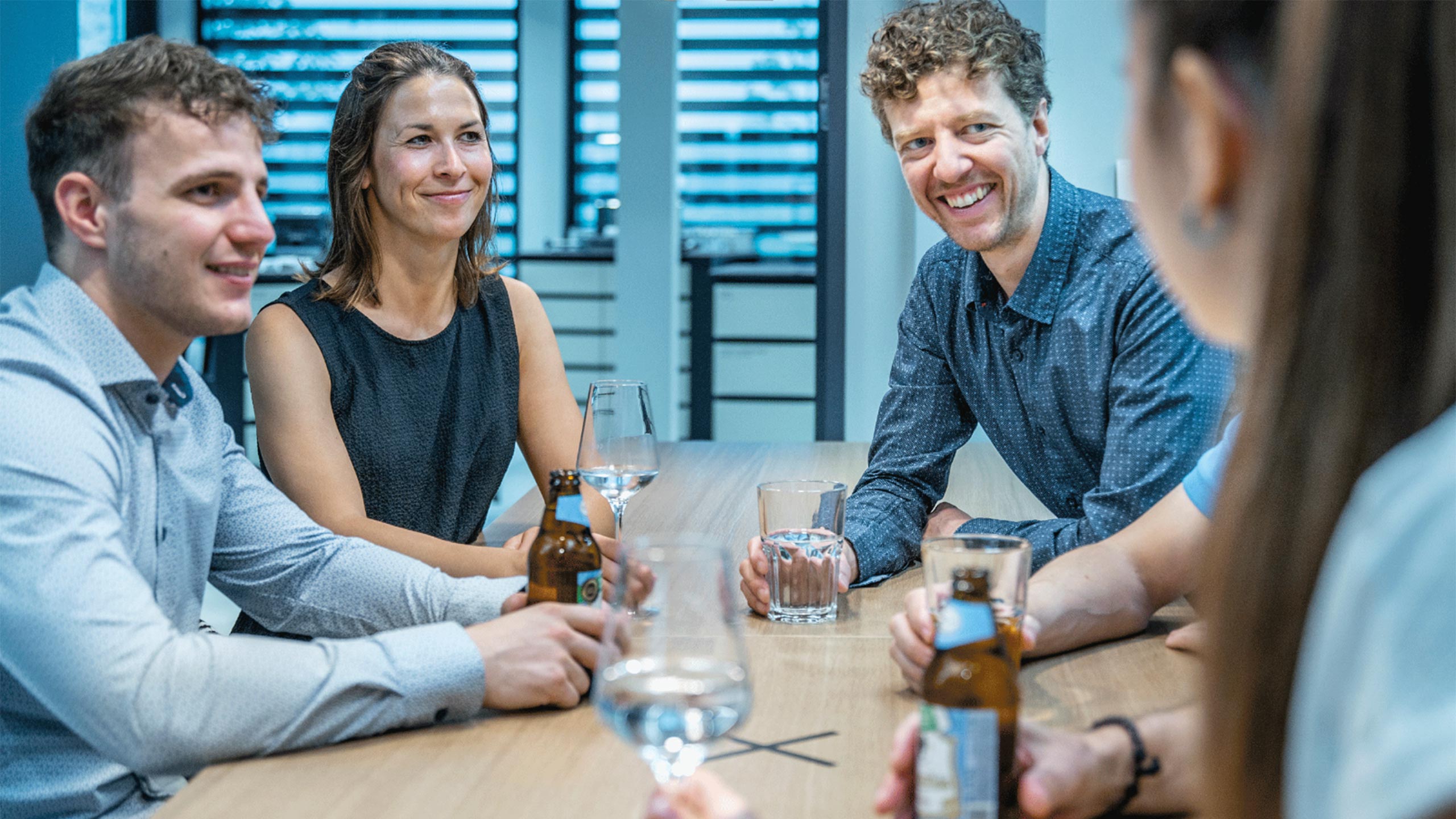 wbi-team-afterwork-web Das Foto zeigt mehrere Mitarbeiterinnen und Mitarbeiter von WBI. Das WBI Team steht im After Work Bereich zusammen und trinkt etwas zusammen.